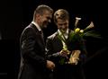 Pan Petr Nekoranec přebírá dřevěnou medaili z rukou Vladimíra Novotného, náměstka hejtmana Kraje Vysočina